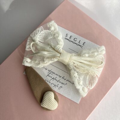 Kreminės spalvos kaspinas į plaukus mergaitėms ir rusvas plaukų segtukas su kremine širdele ant rausvos dėžutės