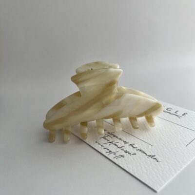 Šviesių karamelinių spalvų plaukų segtukas žnyplės baltame fone