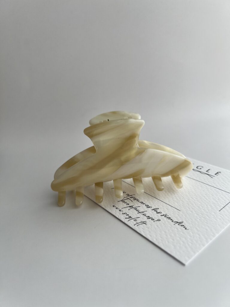 Šviesių karamelinių spalvų plaukų segtukas žnyplės baltame fone