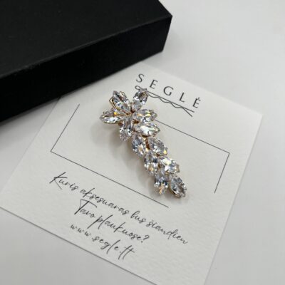 Aukso spalvos metalinis plaukų segtukas dekoruotas blizgančiais cirkoniais. Cirkoniai segtuke išdėstyti gėlės forma