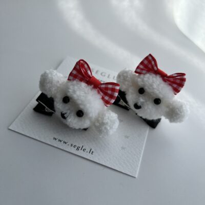 Du plaukų segtukai mergaitėms su baltomis šuniukų galvytėmis. Šuniukai papuošti raudonu languotu kaspinėliu