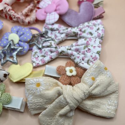 Spalvingi plaukų segtukai ir gumytės mergaitėms rusvame fone