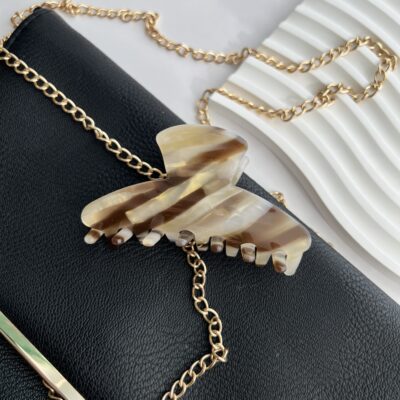 Šviesios spalvos rusvomis linijomis dekoruotas plaukų segtukas žnyplės