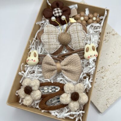 Rusvų spalvų žaismingi plaukų segtukai mergaitėms rudoje dėžutėje