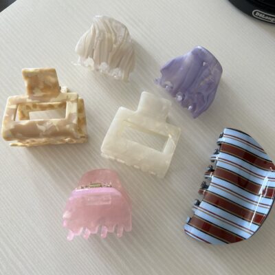 Daug plaukų segtukų žnypliu ant balto paviršiaus