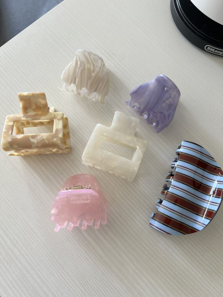 Daug plaukų segtukų žnypliu ant balto paviršiaus