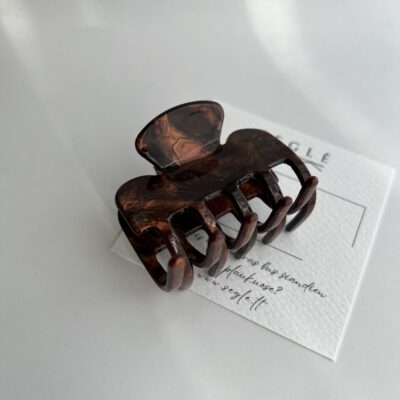 Rudos spalvos plaukų segtukas žnyplės baltame fone