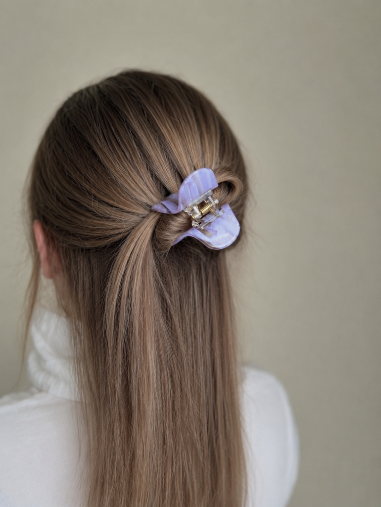 Susegta dalis plaukų su violetinės spalvos plaukų segtuku žnyplėmis. Segtukas nedidelis