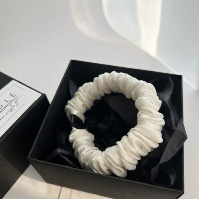 Baltos spalvos nedidelė šilkinė plaukų gumytė juodoje dėžutėje