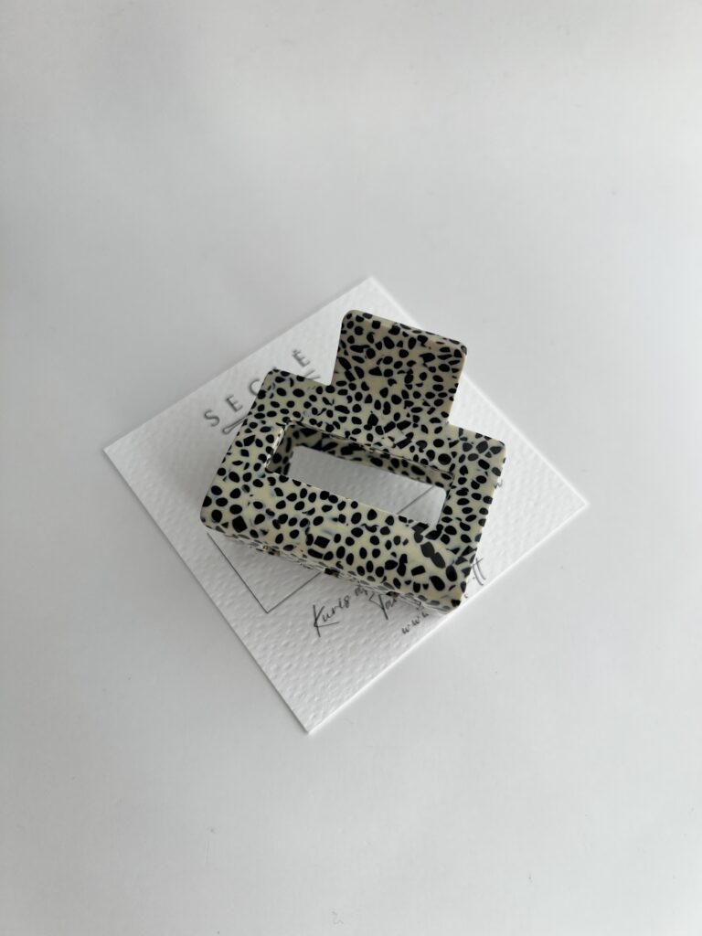 Kreminės spalvos su juodais taškeliais plaukų segtukas žnyplės