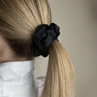 Surišti plaukai su juoda natūralaus šilko gumyte. Plaukų gumytė didesnė.