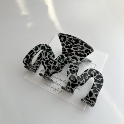 Blizgios pilkos spalvos leopardiniais raštais dekoruotas bangelės formos plaukų segtukas žnyplės