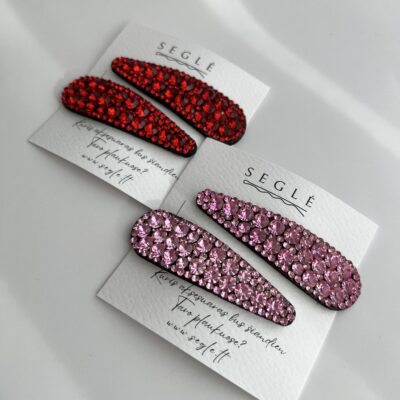 Rausvais ir raudonais akmenukais dekoruoti plaukų segtukai. Segtukai įsegti į baltas korteles