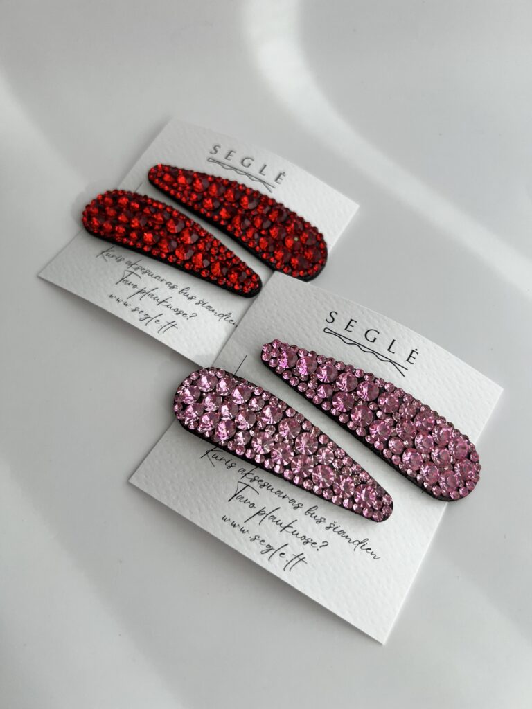 Rausvais ir raudonais akmenukais dekoruoti plaukų segtukai. Segtukai įsegti į baltas korteles