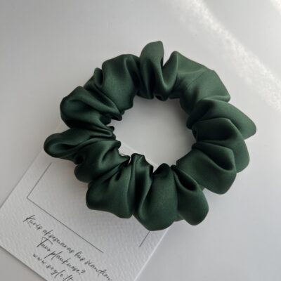 Sodrios žalios spalvos šilkinė plaukų gumytė baltame fone