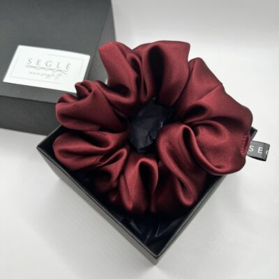 Raudonų rožių žiedlapių spalvos šilkinė plaukų gumytė juodoje dėžutėje