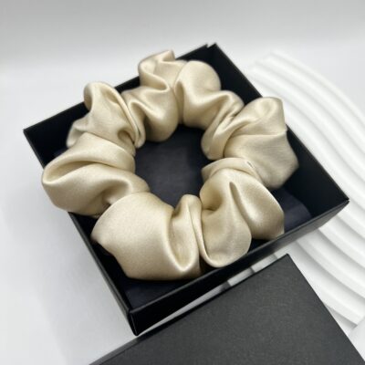 Šampaninės spalvos šilkinė plaukų gumytė juodoje dėžutėje