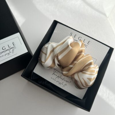 Plaukų segtukas, kuris savo dizainu panašus į kruasaną. Segtukas baltos ir auksinės spalvos