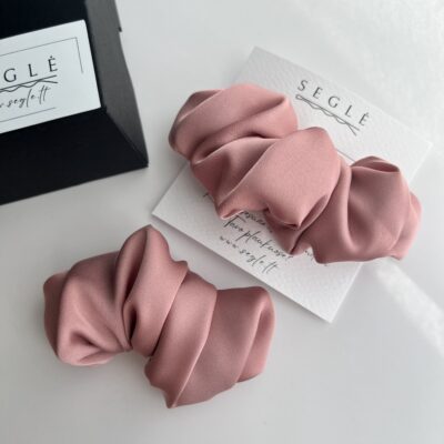 Du rausvos spalvos plaukų segtukai, kurie savo dizainu panašūs į kruasanus