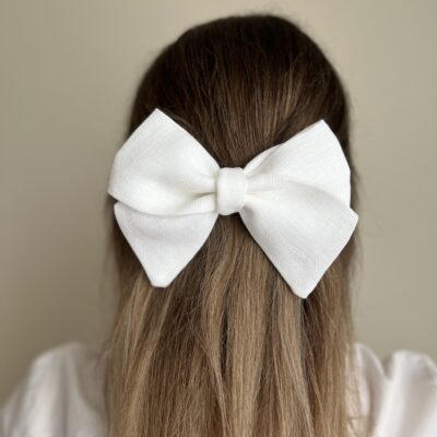 Susegta dalis plaukų su baltu lininiu kaspinu - segtuku