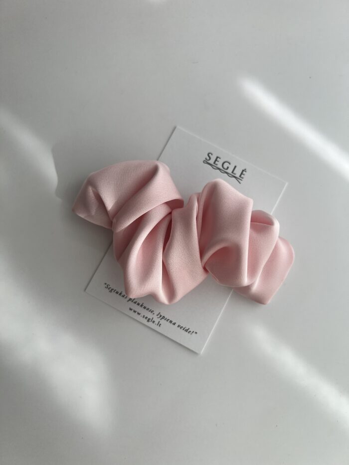 Baby pink spalvos plaukų segtukai, kurie panašūs į kruasanus. Segtuko užsegimas metalinis, paviršius pagamintas iš poliesterio audinio