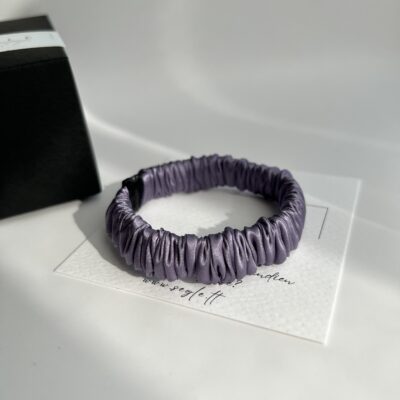 Siaura šilkinė plaukų gumytė. Gumytė baltame fone.