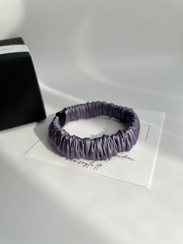 Siaura šilkinė plaukų gumytė. Gumytė baltame fone.