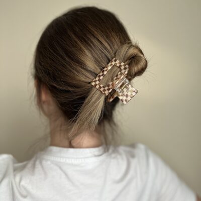 susegti visi plaukai su kvadratiniu plaukų segtuku, kurio paviršius atrodo lyg mozaika