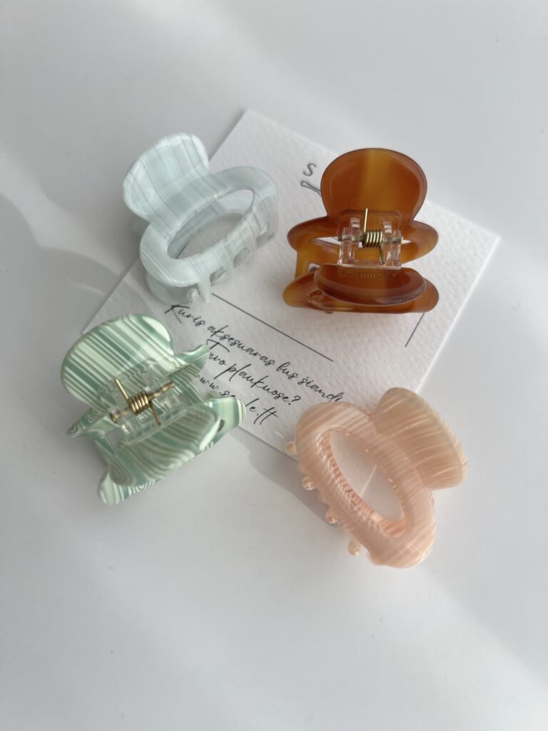 Nedideli, keturių skirtingų spalvų plaukų segtukai baltame fone