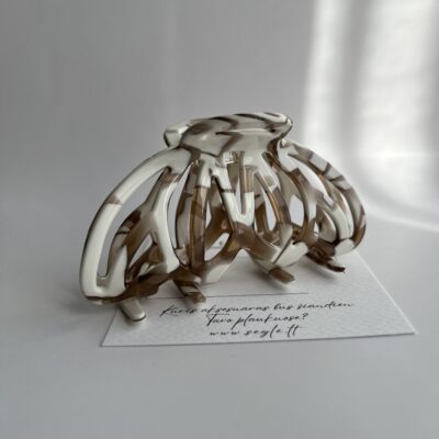 Baltos ir rudos spalvos plaukų segtukas baltame fone