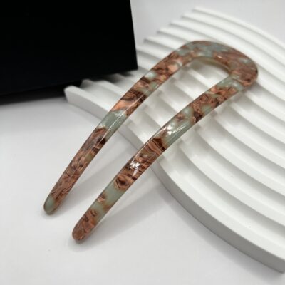 U formos smeigtukas plaukams. Smeigtukas pilkai melsvos spalvos su rudais ornamentais.