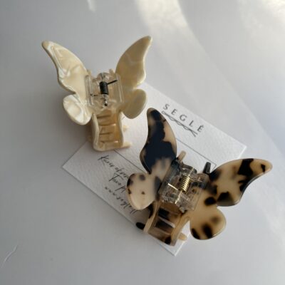 Drugelio formos plaukų segtukai žnyplės. segtukai dviejų spalvų, vienas baltojo šokolado, o kitas migdolinės su juodomis dėmelėmis