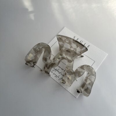 Bangelės formos plaukų segtukas žnyplės baltame fone. segtukas pilkos ir skaidrių baltų spalvų