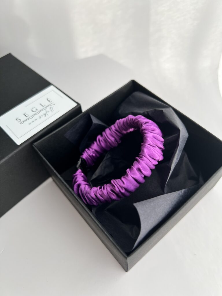 Tamsiai violetinės spalvos nedidelė šilkinė plaukų gumytė juodoje dėžutėje