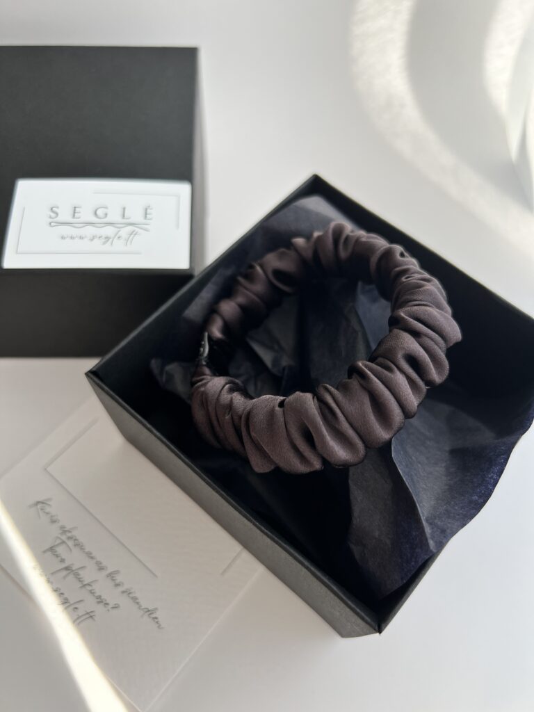 Nedidelė juodojo šokolado spalvos natūralaus šilko plaukų gumytė juodoje dėžutėje