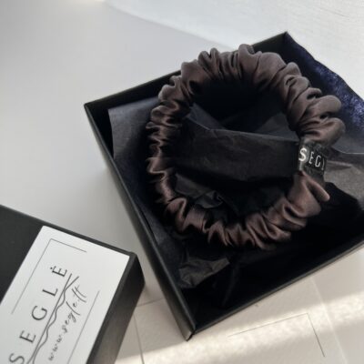 Nedidelė šilkinė plaukų gumytė juodoje dėžutėje. Gumytė juodojo šokolado spalvos