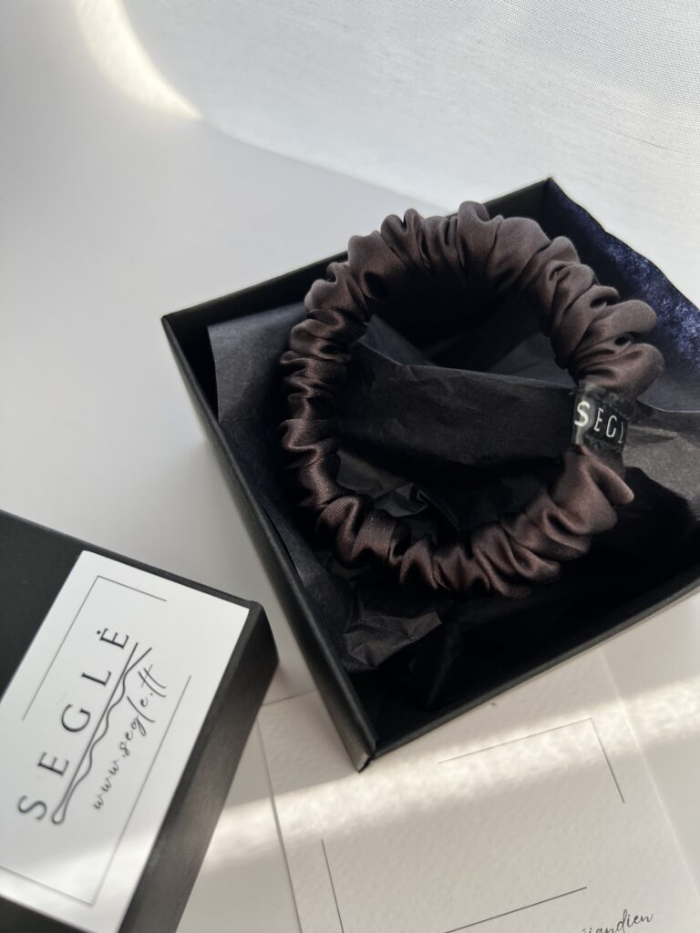 Nedidelė šilkinė plaukų gumytė juodoje dėžutėje. Gumytė juodojo šokolado spalvos
