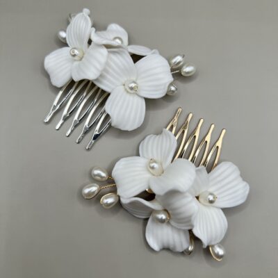 Dvi metalinės plaukų sagės nuotakų šukuosenoms. Viena sagė aukso spalvos, kita sidabro. sagės dekoruotos baltomis keramikinėmis lelijomis