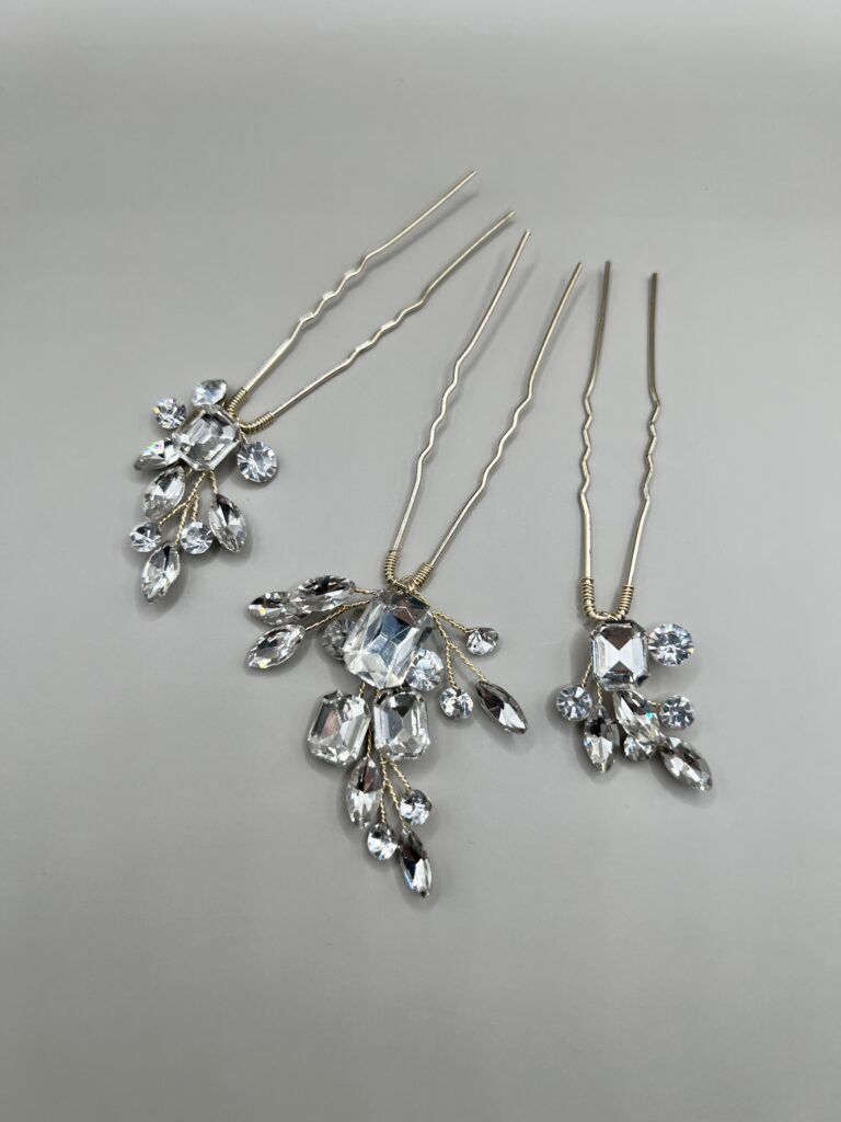 Metaliniai šviesios aukso spalvos plaukų smeigtukai dekoruoti skaidriais kristaliukais, kurie išdėstyti šakelių forma