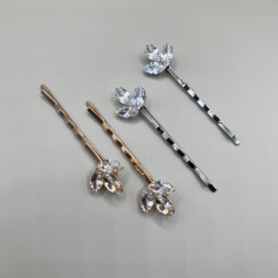 Metaliniai plaukų segtukai dekoruoti blizgančiais cirkoniais, kurie išdėstyti žiedlapio forma. Segtukai sidabro ir aukso spalvos