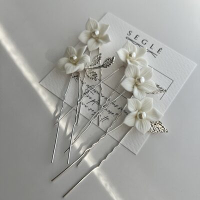 Metaliniai smeigtukai plaukams dekoruoti baltomis gėlėmis. Metalo spalva sidarbrinė