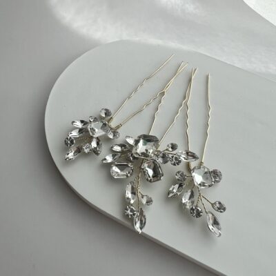 Metaliniai smeigtukai plaukų kuodui dekoruoti blizgančiais akmenukais. Akmenukai išdėstyti šakelėmis