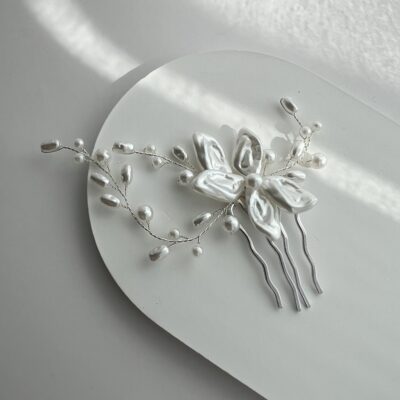 Metalinė plaukų sagė nuotakoms vestuvinėms šukuosenoms. Sagė dekoruota balta gėle ir šakelėmis su dirbtiniais perliukais