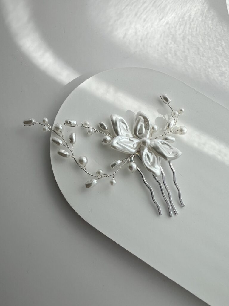 Metalinė plaukų sagė nuotakoms vestuvinėms šukuosenoms. Sagė dekoruota balta gėle ir šakelėmis su dirbtiniais perliukais