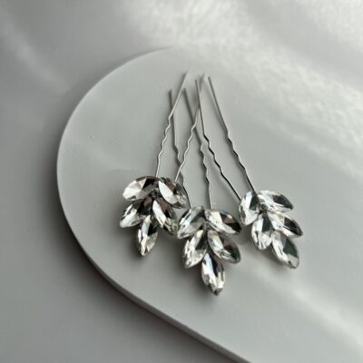 Metaliniai smeigtukai plaukams dekoruoti skaidriais akmenukais. Smeigtukų metalo spalva sidabrinė.